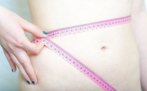 Cô gái đo vòng eo để ghi lại kết quả thực hiện chế độ ăn kiêng Dukan